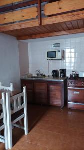 圣贝尔纳多Departamento de 2 ambientes y medio c/entrada de auto的带水槽和炉灶的厨房