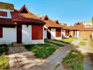 圣贝尔纳多Departamento de 2 ambientes y medio c/entrada de auto的一排红色屋顶的房子