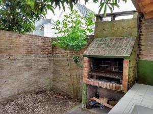 圣贝尔纳多Departamento de 2 ambientes y medio c/entrada de auto的砖墙中的室外砖炉 更多1张照片