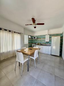 a kitchen with a wooden table and white chairs at La Morenita in Colón