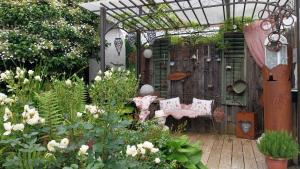 a garden with a pergola and chairs and flowers at Thalerhof in Roppen
