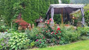 a garden with a gazebo and a bunch of flowers at Thalerhof in Roppen
