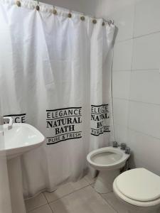 a bathroom with a toilet and a shower curtain at La Morenita in Colón +3 photos