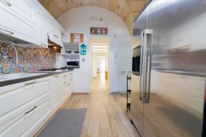 a kitchen with white cabinets and a stainless steel refrigerator at Holiday Home San Lazzaro in Lecce