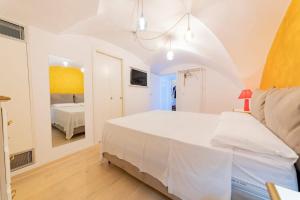 a white bedroom with a bed and a mirror at Holiday Home San Lazzaro in Lecce