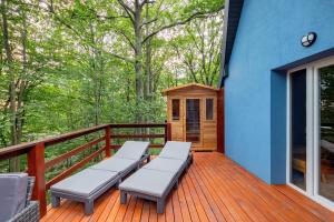 a deck with two benches and a tiny house at LOMBDELUXE BLUE 749 in Mátraszentimre
