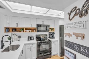 ネープルズにあるRemodeled Luxury Condo with Lake Viewsの白いキャビネットとステンレス製の電化製品を備えたキッチン