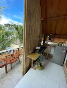 a kitchen with a stove and a table and a balcony at Nelly Homestay Bungalows Gili Air in Gili Air