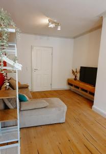 an empty living room with a couch and a flat screen tv at 2BR Wohnen mit Aussicht in der malerischen Altstadt - gemütlich & zentral in Schwäbisch Hall