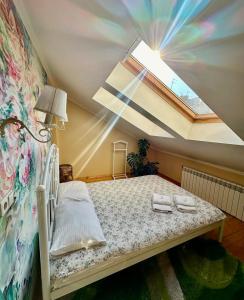 1 dormitorio pequeño con 1 cama con tragaluz en Apartments My London, en Chernivtsi