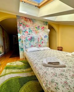 Un dormitorio con una cama grande con una pared floral. en Apartments My London, en Chernivtsi
