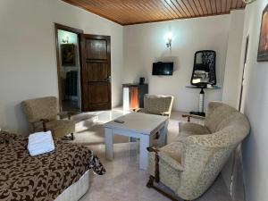 a living room with a bed and a table and chairs at Hotel Cattaleya in Batumi