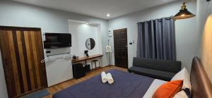 a room with a bed and a desk and a television at Lanta Mango Beach Houses in Phra Ae beach