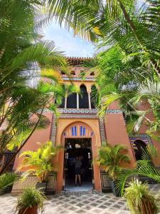 アルムニェーカルにあるCasa Finaのヤシの木のある建物の入り口に立っている人 +25枚の写真