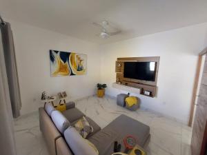 a living room with a couch and a flat screen tv at Cantinho do sossego in Ilhéus