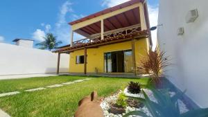 a rabbit sitting in front of a yellow house at Cantinho do sossego in Ilhéus