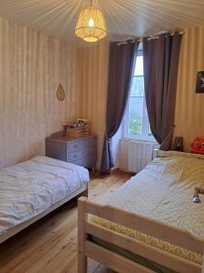 Un dormitorio con dos camas y una ventana. en Gîte 4 pers avec option sauna- Classé 3 étoiles- Sud charente, en Lagarde-sur-le-Né