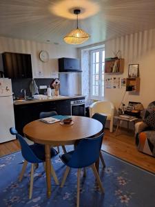 Una cocina y una sala de estar con mesa y sillas. en Gîte 4 pers avec option sauna- Classé 3 étoiles- Sud charente, en Lagarde-sur-le-Né