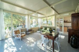 een grote woonkamer met ramen en een tafel bij Azalo Country House in Noto
