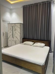 a large bed in a room with a curtain at Plot9 Road9 NTA road in Port Harcourt