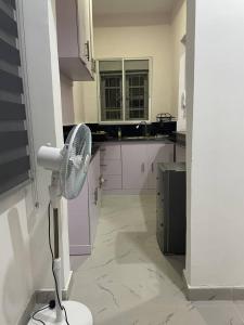 a white kitchen with a fan in a room at Plot9 Road9 NTA road in Port Harcourt