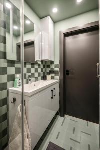 a bathroom with a white sink and a door at GoldenHugo rooms Self check in Pet friendly in Vilnius