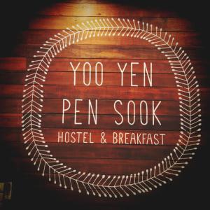 um sinal numa parede de madeira com as palavras "sushi de caneta ano" em Yoo Yen Pen Sook em Banguecoque