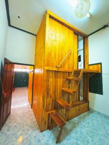 a room with a wooden wall with a book shelf at Aloha LuangPrabang Hostel Capsule in Luang Prabang
