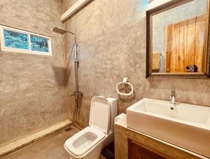 Un baño con lavabo, inodoro y espejo. en Dharma Place, en Ahangama 104 fotos más