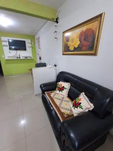 ディアマンティーナにあるCasa em Diamantina-MGの革張りのソファとテレビのあるリビングルーム