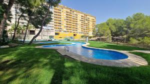 a swimming pool in a park with a building at Apartment Bella Vista with sea view in Dehesa de Campoamor +26 photos