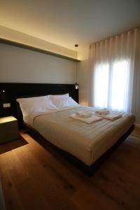 a bedroom with a large white bed with a window at Agriturismo Borgo Riva Granda in Col San Martino