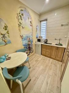 a kitchen with a table and chairs and a sink at Little Paris Apartment in Chernivtsi +4 photos