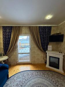 a living room with a fireplace and a window at Little Paris Apartment in Chernivtsi