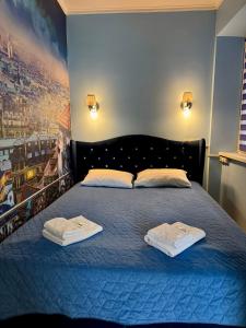 a bedroom with a blue bed with towels on it at Little Paris Apartment in Chernivtsi