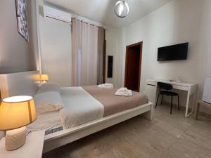 a bedroom with a bed and a desk with a computer at Vespro Guest House in Messina