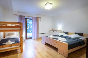 a bedroom with two beds and a bunk bed at Apartmanica Fairy Tale, JASNÁ - SKI TÁLE- MÝTO POD ĎUMBIEROM, 3 apartments in 1 house, fireplace, free parking in Horná Lehota