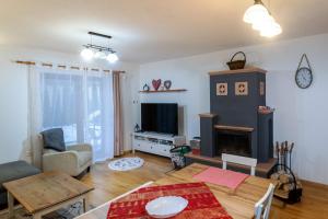 a living room with a table and a fireplace at Apartmanica Fairy Tale, JASNÁ - SKI TÁLE- MÝTO POD ĎUMBIEROM, 3 apartments in 1 house, fireplace, free parking in Horná Lehota
