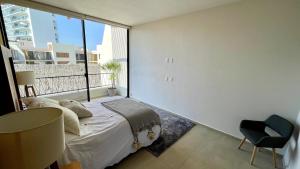 ブセリアスにあるBucerias apartment with rooftop and poolのベッドと大きな窓のある寝室 +37枚の写真