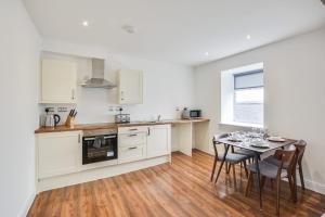 a kitchen and dining room with a table and chairs at Host & Stay - Canalside Lofts Apartment in Burnley