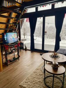 a living room with a tv and a large window at Vila Edi Tuzla in Tuzla