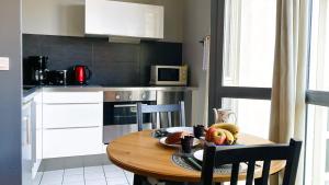 a kitchen with a wooden table with a plate of food on it at 5ème Ciel - Première Conciergerie in Montpellier