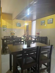 a dining room with chairs and a table with flowers on it at Hotel Gasometro in São Paulo