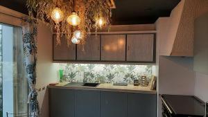 a kitchen with a chandelier hanging over a counter at Neo-retro sixties in Dunkerque