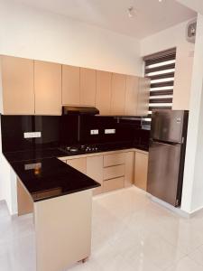 a kitchen with a black and stainless steel refrigerator at URBAN 17 - Experience comfort & convenience in Moratuwa