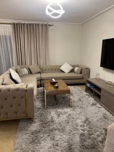 a living room with a couch and a coffee table at شقة فندقية نيو جيزة الشيخ زايد in Abū Rawwāsh