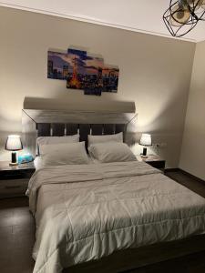 a bedroom with a large white bed with two lamps at شقة فندقية نيو جيزة الشيخ زايد in Abū Rawwāsh