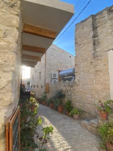 a stone building with potted plants on a walkway at Vouni Calais in Vouni