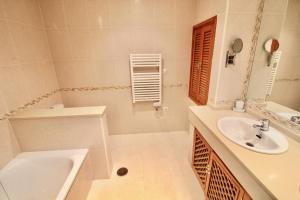 ein weißes Badezimmer mit Waschbecken und Badewanne in der Unterkunft Beautiful Three-Bedrooms El Rancho Villa in Atamaría + 13 Fotos