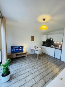 a living room with a table and a kitchen at Le Studio de Théa - Private Parking - 2 Guests in Le Mans